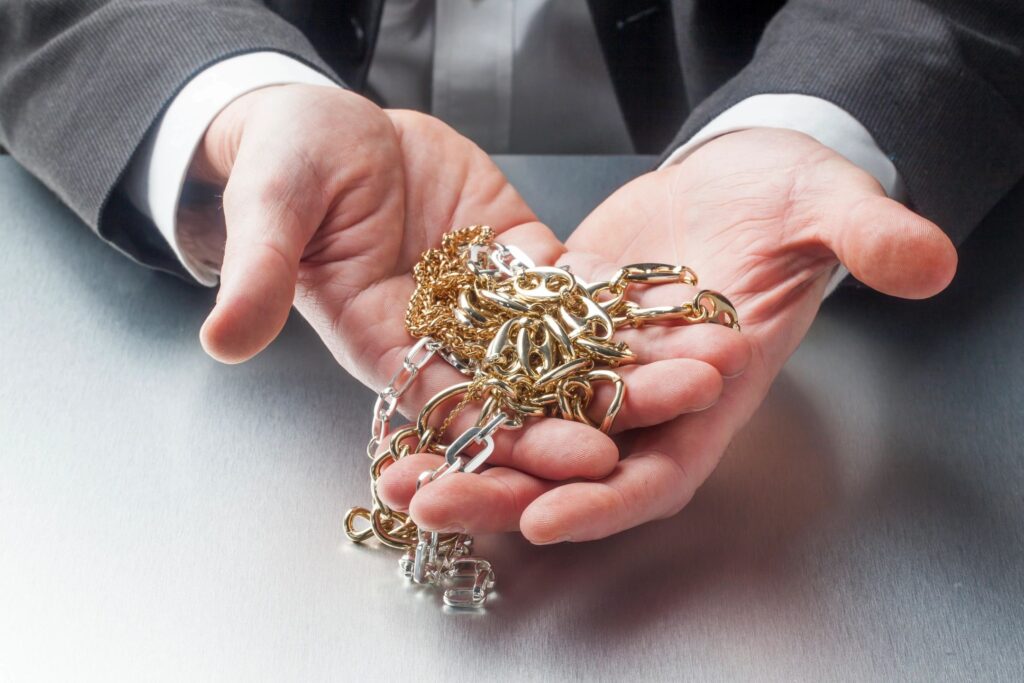 Hands with gold jewelry chains